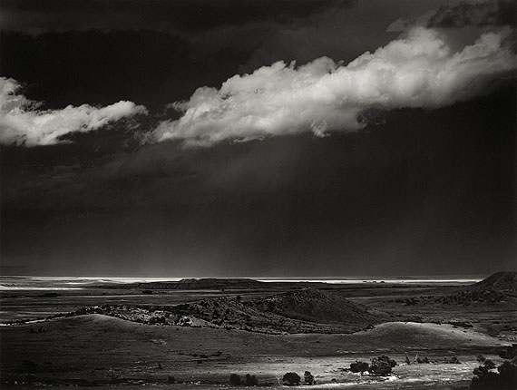 Ansel AdamsSTORM OVER THE GREAT PLAINS FROM CIMARRON, NEW MEXICO. 1960Gelatin silver print, c. 1975. 37,3 x 49,2 cm. Laid down on original cardboard, thereupon lower right signed in pencil. On the reverse of the cardboard photographer's stamp, therein dated and inscribed in black felt-tip pen. Courtesy Villa Grisebach Auktionen