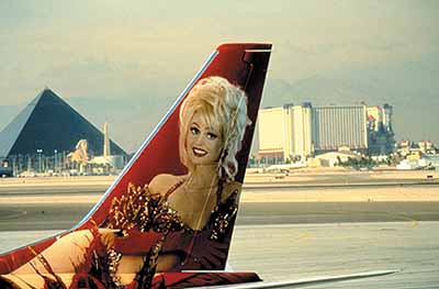 © Lauren Greenfield,The image of Aki, the star showgirl of the Stardust Hotel, on a tail of an airplane, Las Vegas, Nevada.