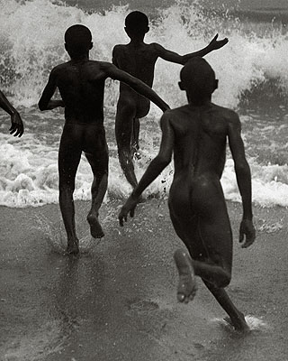 Drei Jungen laufen in die Brandung des Tanganyika-Sees, um 1930 veröffentlicht in: Das Deutsche Lichtbild 1932 Fotografiert von Martin Munkácsi, © Joan Munkácsi. Courtesy ullstein bild 