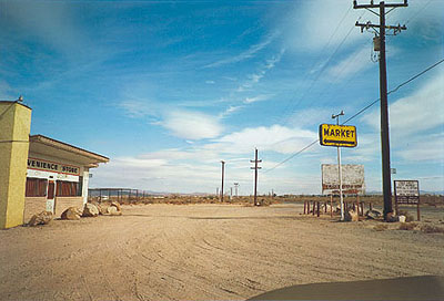 William Eggleston. Untitled, (Yellow Market Sign and Parking Lot), 1999-2001 ©Eggleston Artistic Trust