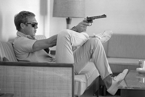 Steve McQueen aims a pistol in his living room, California 1963. © John Dominis / Time Inc. All Rights Reserved.